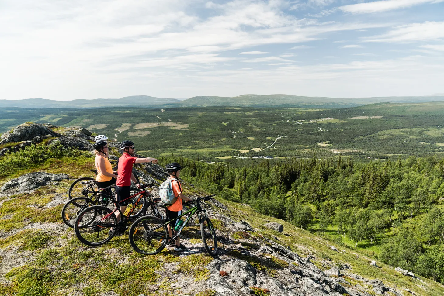 Familj blickar ut på fjällen på sina mtb-cyklar