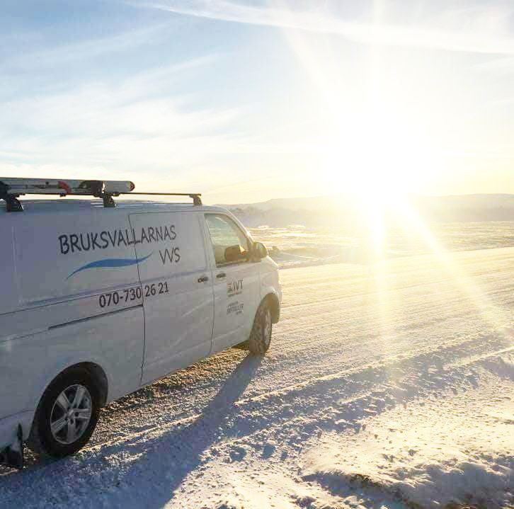 Skåpbil med Bruksvallarnas VVS logotyp, på snöig väg i skolsken.