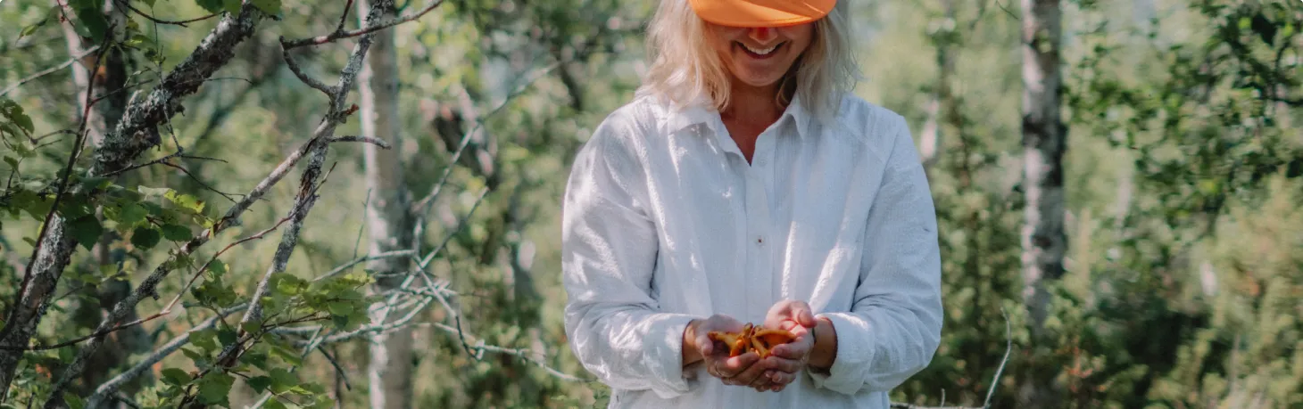 Kvinna plockar svamp i fjällmiljö