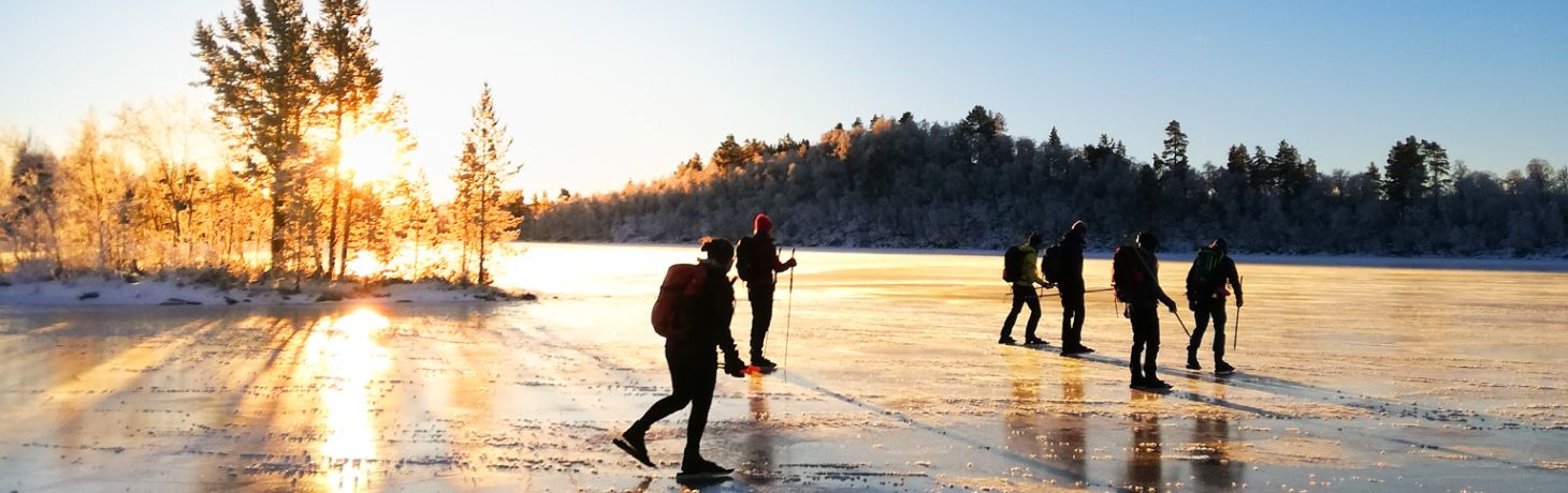 Personer åker långfärdskridskor på en sjö i Funäsfjällen
