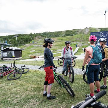 Cyklister står i grupp utanför Ski lodge i Tänndalen
