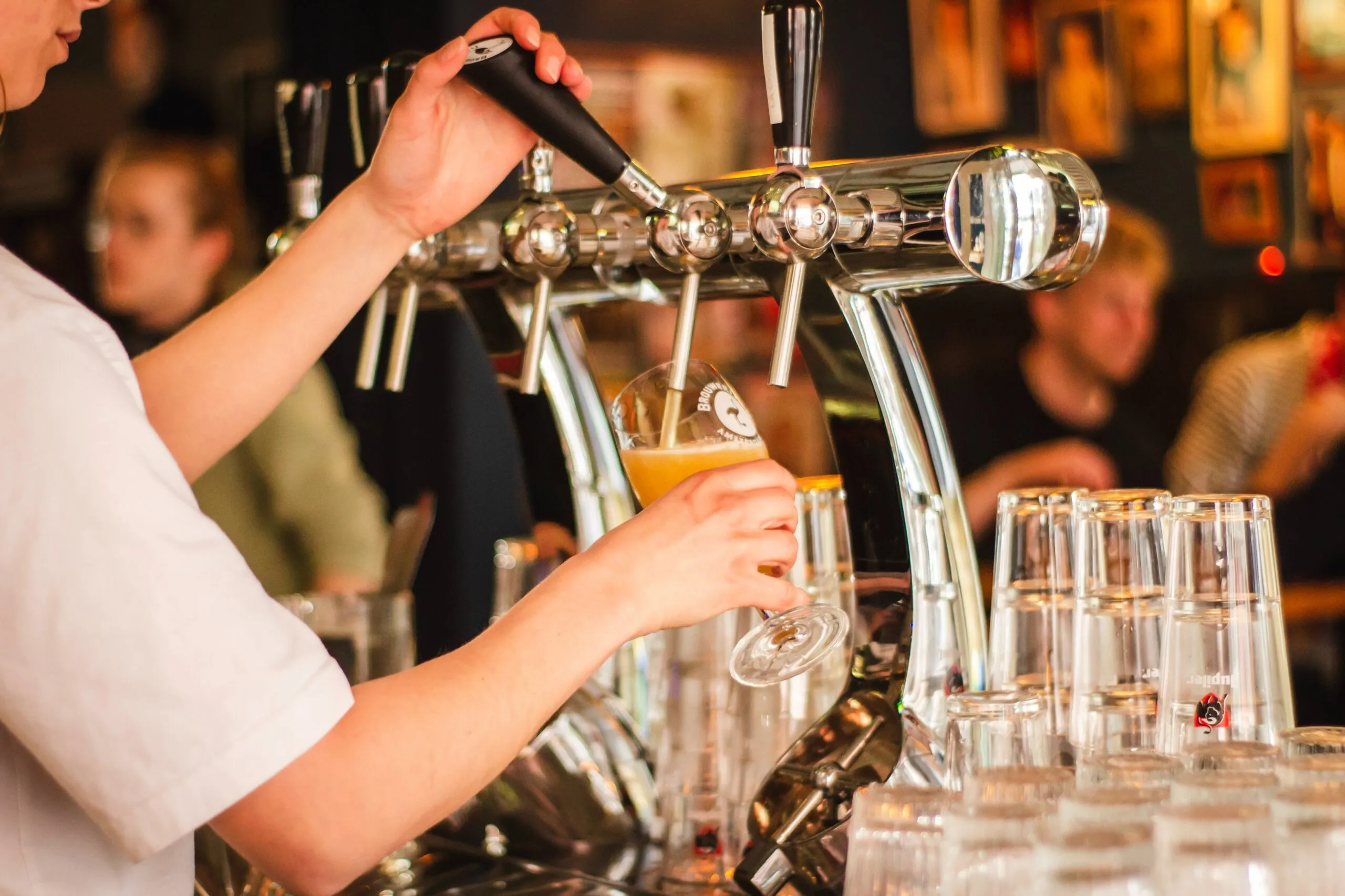 Bartender som fyller upp ett ölglas.
