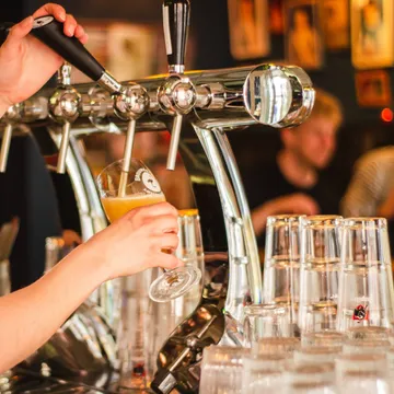 Bartender som fyller upp ett ölglas.