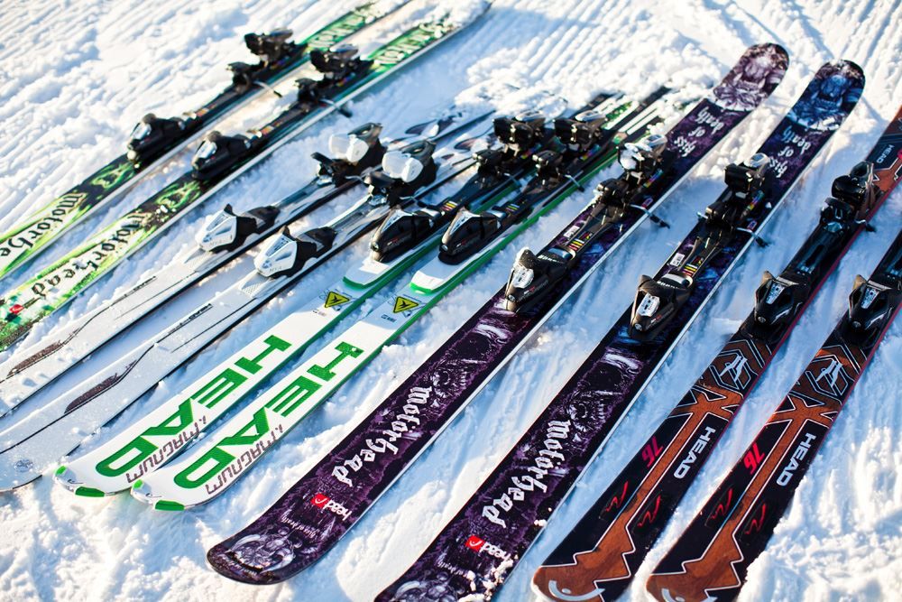 Flera par slalomskidor bredvid varandra i snön.