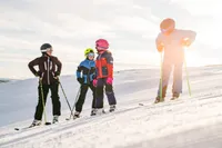 Familj åker skidor i backen