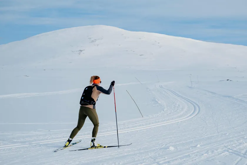 Kvinna åker längdskidor på fjället