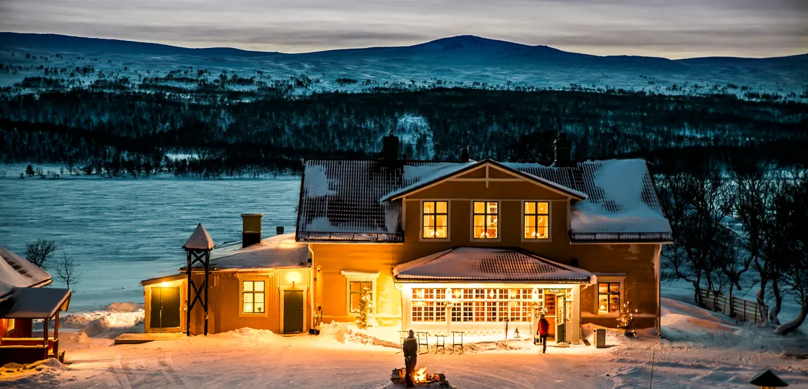 Fjällnäs restaurang, vintertid, med lampor som lyser i fönstren.