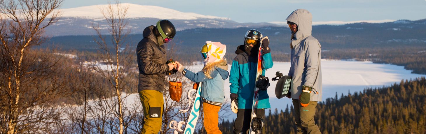 Familj åker skidor med barn